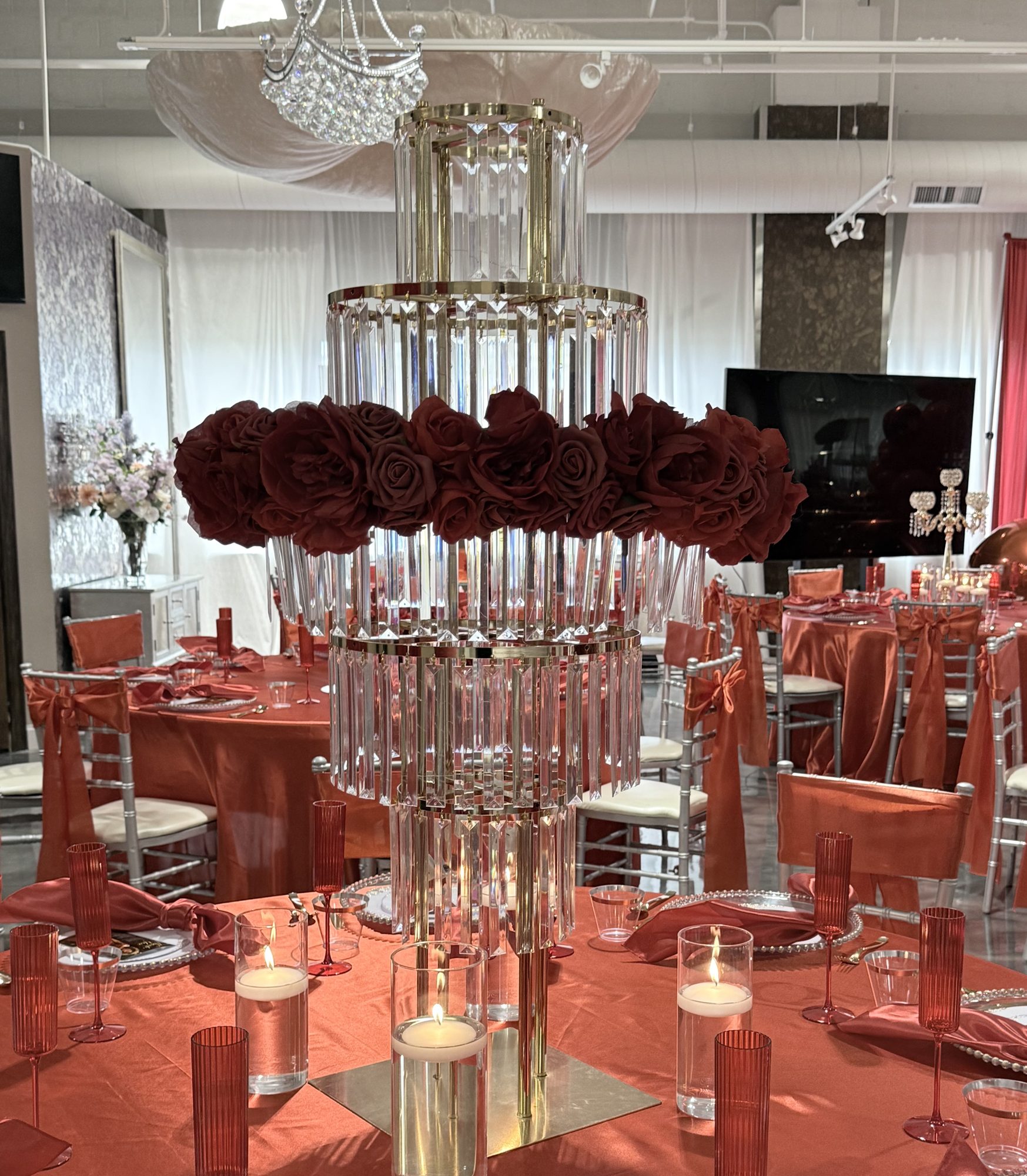 A crystal and rose centerpiece on a set table